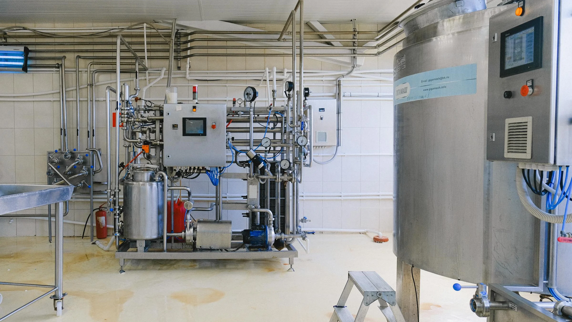 Stainless industrial cleaning equipment with control panels and piping